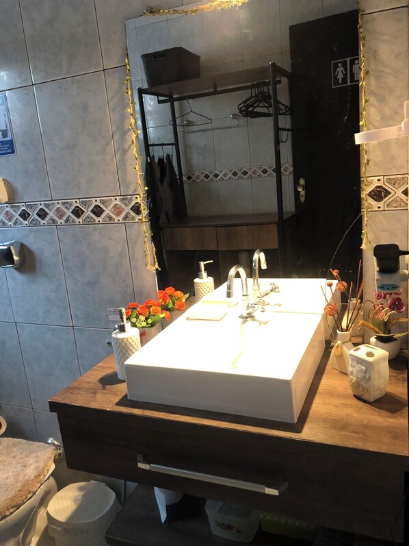 A bathroom with a white sink, a mirror, and a towel rack.