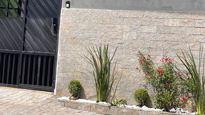 A building with a grey facade, a black gate, and the number 122. - Single Room Centro Avaré  (Braz II Avaré)