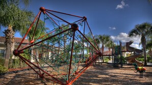 A playground with a climbing structure and a slide. - Disney Trail-Much loved 2 bedroom Oakwater condo, just 1.5 miles from Disney! (Kissimmee)