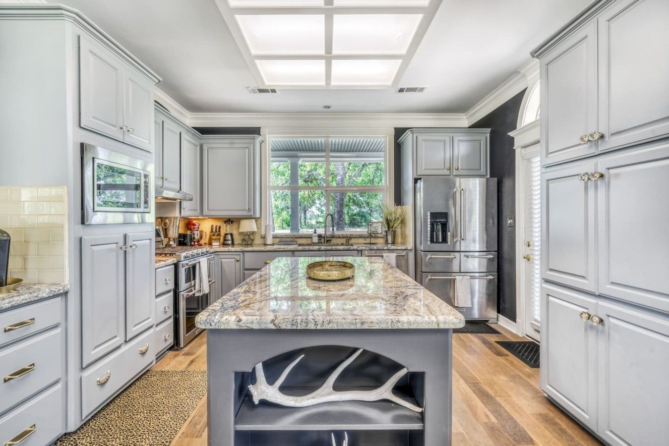 A spacious kitchen with marble countertops, stainless steel appliances, and a large island.