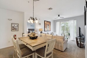 A dining area with a wooden table and chairs, a chandelier, and a fire extinguisher on the wall. - Disney Wonder-Beautiful 2 bed Windsor Hills condo, just 1.5 miles from WDW! (Four Corners)