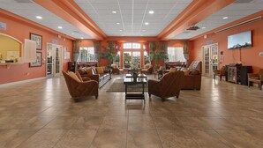 A spacious lobby with a high ceiling, multiple seating areas, and a large window providing natural light. - Lakeside-Beautiful 3 bed Oakwater condo over the lake, just 1.5 miles from WDW! (Kissimmee)