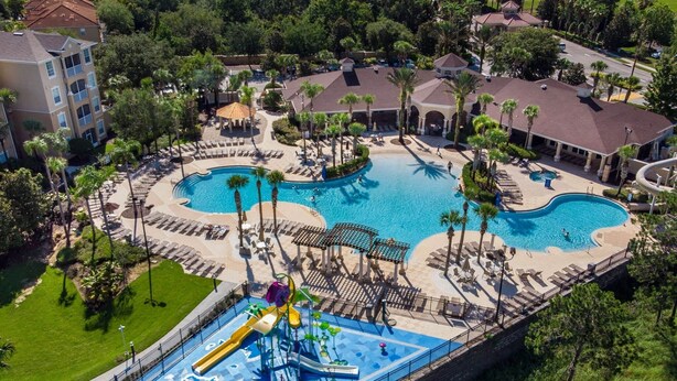 Ein Resort mit zwei Schwimmbecken, einem Wasserpark und einer gepflegten Rasenfläche.