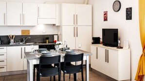 A compact living space with a kitchenette, dining area, and a sofa.