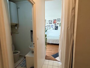 Un bagno con il water, un lavandino e uno scaldabagno.