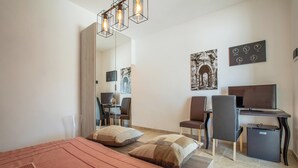 Una habitación de hotel moderna con cama, escritorio, silla y televisor.
