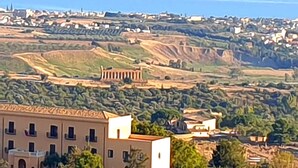 Une ville côtière qui se distingue par un bâtiment remarquable, doté d’un balcon et offrant une vue sur la mer.