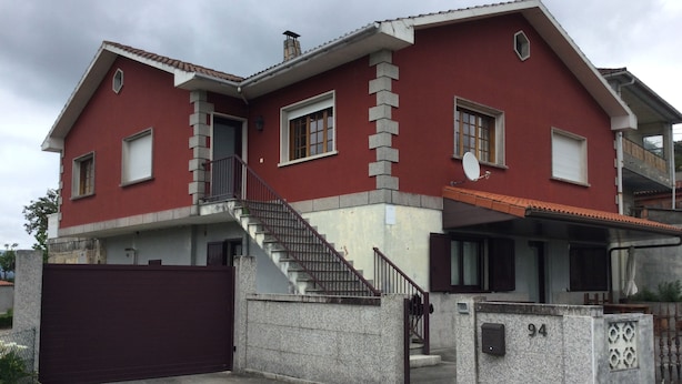 A two-story house with a red facade, a stone staircase, and a gated entrance. - Large renovated country house in a relaxing natural location (Pontevedra)