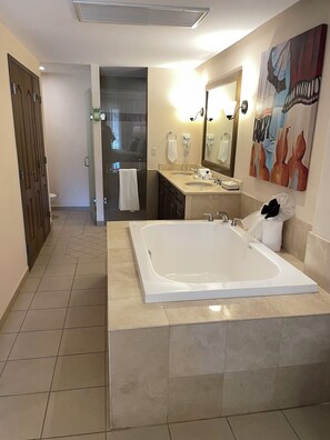 Ein modernes Badezimmer mit einer großen Badewanne, zwei Waschbecken, einer Dusche und einem WC.