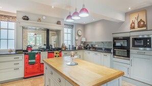 A modern kitchen with a central island, stainless steel appliances, and pendant lighting.