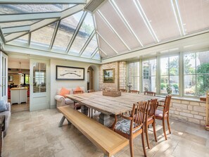 A spacious room with a large wooden table, comfortable seating, and a glass ceiling allowing natural light. - 5 bedroom accommodation in Burton Pedwardine, near Sleaford (Burton Pedwardine, near Sleaford)