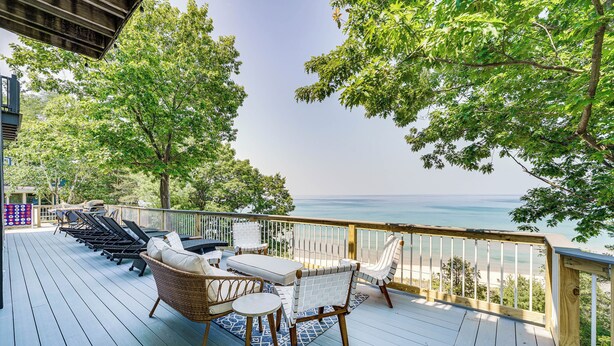 A deck with outdoor furniture overlooking a beach. - Private Beachfront Lake Michigan Rental w/ Kayaks (Pentwater)