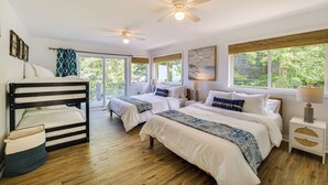 A bedroom with two beds, wooden flooring, ceiling fans, large windows, and a balcony. - Private Beachfront Lake Michigan Rental w/ Kayaks (Pentwater)