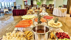 Un buffet proposant divers plats et un coin dédié au chocolat chaud, installé dans la salle à manger d’un hôtel.