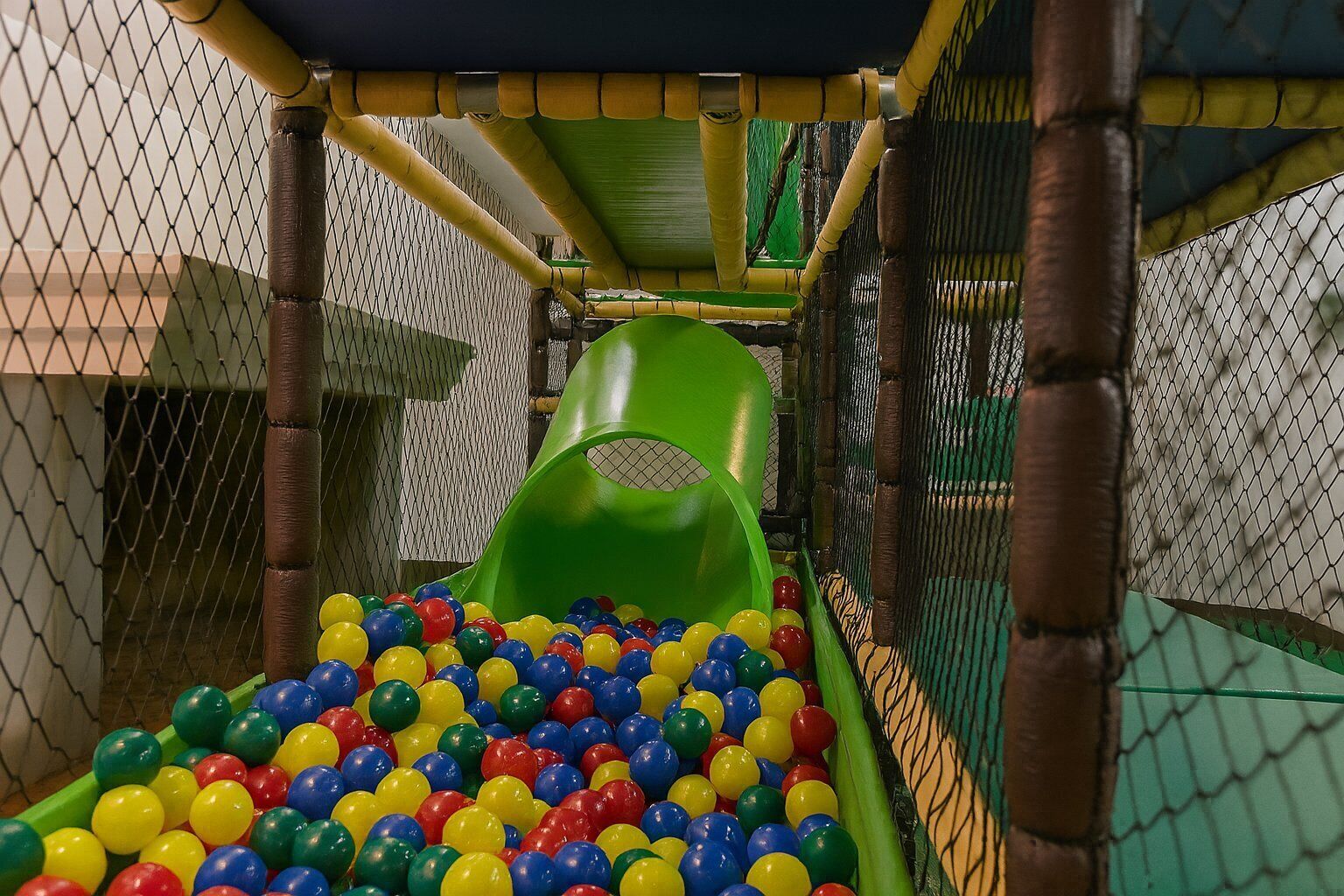 A play area with a slide and a ball pit filled with multicolored balls.