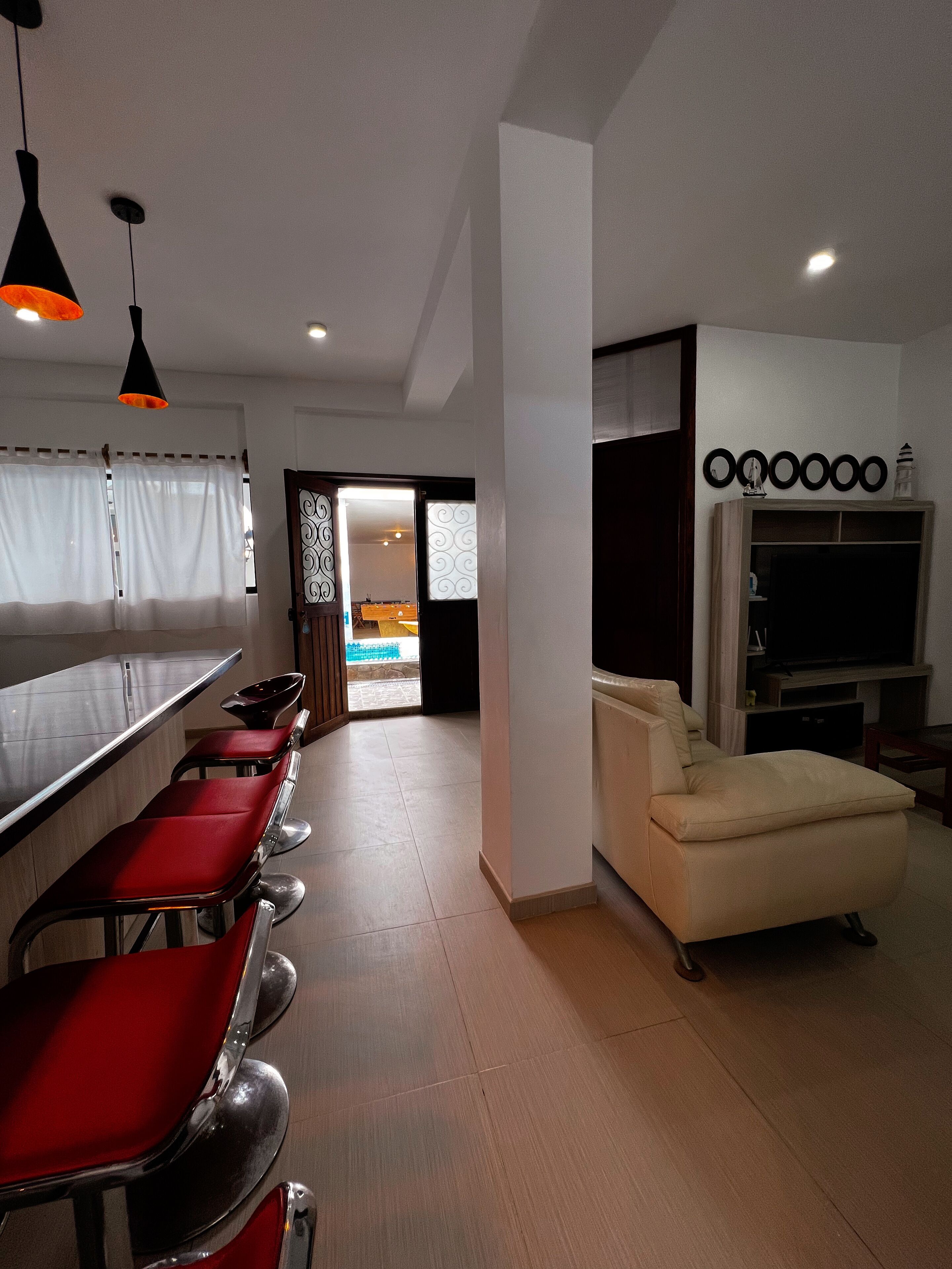 Una cocina moderna con barra, sofá y televisor.