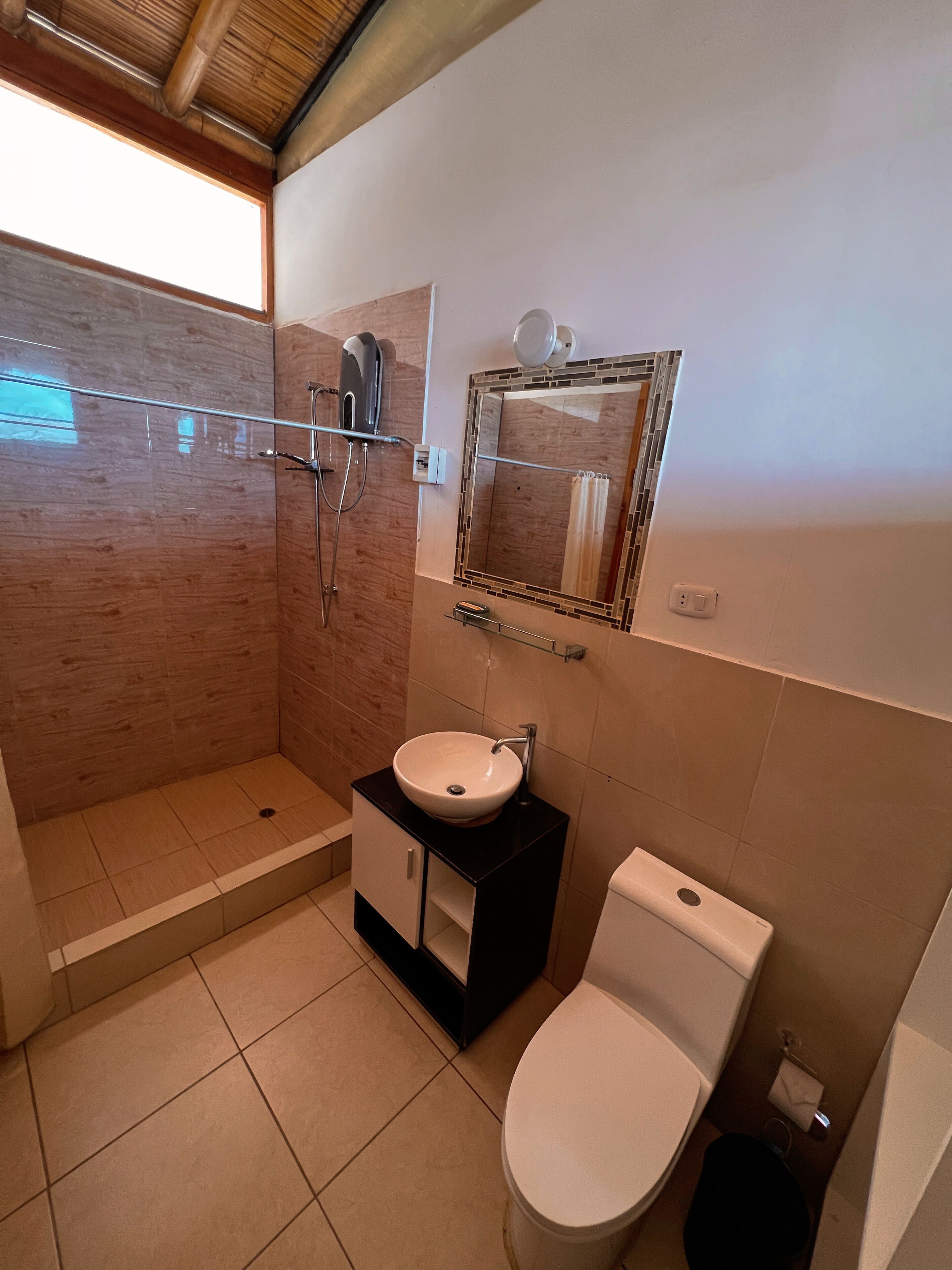 A bathroom with a shower, sink, and toilet.