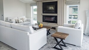 A modern living room with a sofa, armchairs, a coffee table, and a fireplace. - Stan Hollis Lodge - UKC4063 (Great Ayton, near Stokesley)