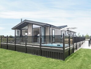 A modern house with a glass-enclosed deck, a hot tub, and a covered patio area. - Stan Hollis Lodge - UKC4063 (Great Ayton, near Stokesley)