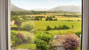 A view from a window overlooking a green field with trees and distant hills. - 2 bedroom accommodation in Bassenthwaite, near Keswick (Bassenthwaite, near Keswick)