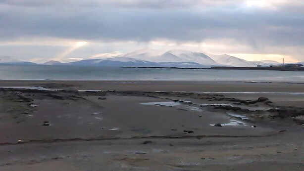 A beach with a view of mountains in the background. - 2 bedroom accommodation in Ardrossan, near Ayr (Ardrossan, near Ayr)