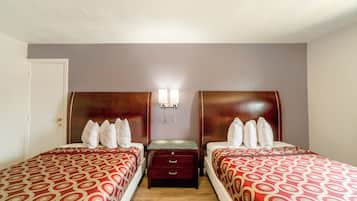 A twin room with two beds, a nightstand, and a wall-mounted light.