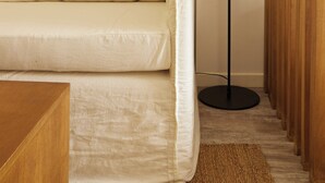 A modern living room with a sofa, a floor lamp, and a wooden panel wall. - Hestia at Cabrera 3200 (Buenos Aires)