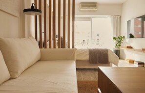 A modern bedroom with a large bed, a bedside table, a desk, and a potted plant. - Hestia at Cabrera 3200 (Buenos Aires)