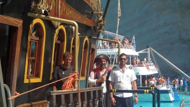 Ein Schiff mit einem Deck, einem Rettungsboot und einer Reling.