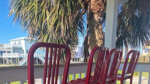 A wooden deck with red metal chairs. - Beautiful Beach House In Fort Morgan !  (Gulf Shores)
