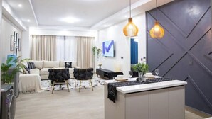 Una sala de estar moderna con sofá, mesa de centro e iluminación colgante.