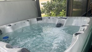 Ein Whirlpool mit Blick auf grüne Landschaft.