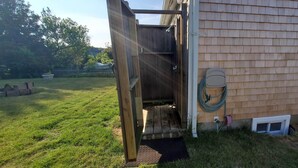 Um deck de madeira com porta de correr que dá para uma área coberta.