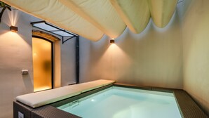 A spa area with a hot tub, a wall-mounted light, and a ceiling fan. - Gallo Cedrone a Home With Outdoor (Lucca)