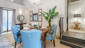 A dining area with a chandelier, a large potted plant, and a staircase leading to an upper level. - Gallo Cedrone a Home With Outdoor (Lucca)