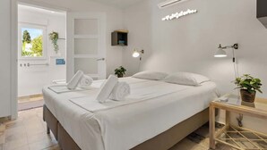 A modern hotel room with a large bed, two bedside tables, an air conditioning unit, and a window with a view of greenery. - Family Apartment with Pool by Costarentals - Ref 218 (Torremolinos)