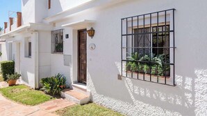 A white building with a number '9' sign, a wooden door, and a window with metal bars. - Family Apartment with Pool by Costarentals - Ref 218 (Torremolinos)