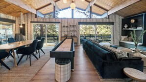 A spacious room with a pool table, a dark blue sofa, and a wooden ceiling.