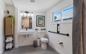 A modern bathroom with a toilet, sink, and towel rack. - The Stillwater Retreat (Stillwater)