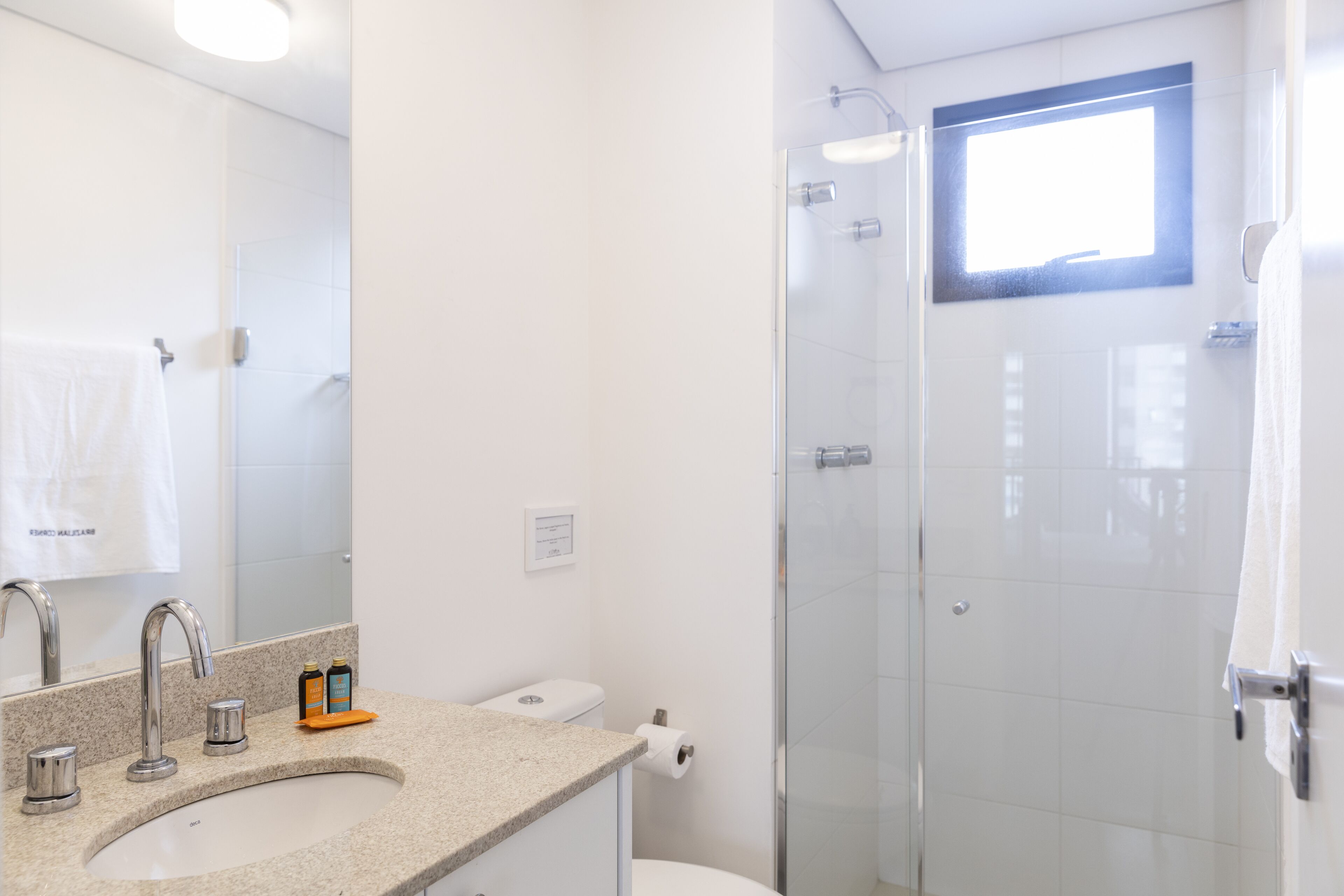 Ein Badezimmer mit Waschbecken, Spiegel und einer Duschkabine.