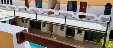 Un hotel con piscina, mobiliario de exterior y tejado de tejas rojas.