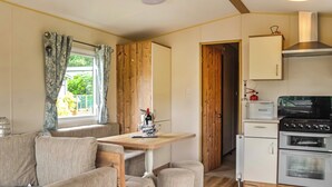 A compact kitchen with a stove, oven, and a small cabinet labeled 'BREAD'. - 2 bedroom accommodation in Kippford, near Sandyhills (Kippford, near Sandyhills)