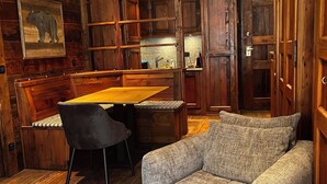 Ein gemütliches Zimmer mit Holzmöbeln, einem Esstisch und einer Couch.