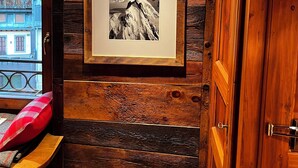 Eine Holzwand mit einem gerahmten Foto einer Berglandschaft.