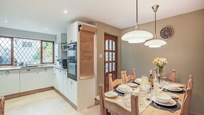 Une cuisine moderne avec des meubles blancs, un four encastré et une fenêtre offrant une belle vue.