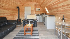 A cozy cabin interior with a living area, a kitchenette, and a dining space.