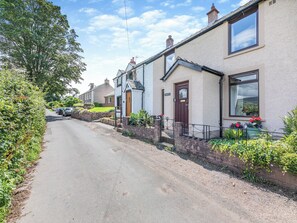 A residential street with houses, a clear sky, and a parked car. - 3 bedroom accommodation in Brampton, near Appleby-in-Westmorland (Brampton, near Appleby-in-Westmorland)