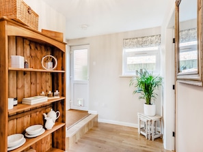 Ein Holzinterieur mit Regalen, einer Topfpflanze und einem Fenster.