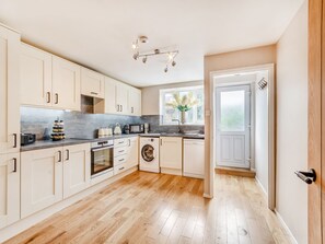 A modern kitchen with white cabinets, a built-in oven, microwave, and dishwasher. - Wheelwright's Cottage (Rodsley, near Ashbourne)