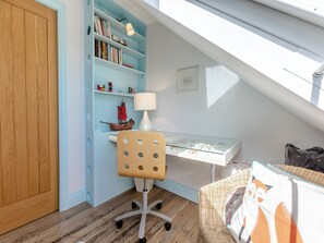 A study with a desk, chair, bookshelf, and a small ship model. - 4 bedroom accommodation in St. Mawes (St. Mawes)